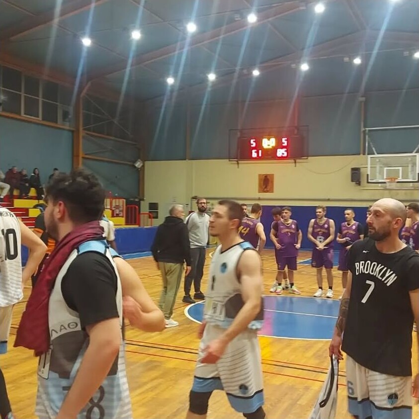 Παίκτες μπάσκετ σε αγωνιστική στιγμή στο κλειστό γήπεδο