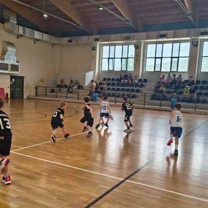 Μικροί αθλητές παίζουν μπάσκετ σε κλειστό γήπεδο